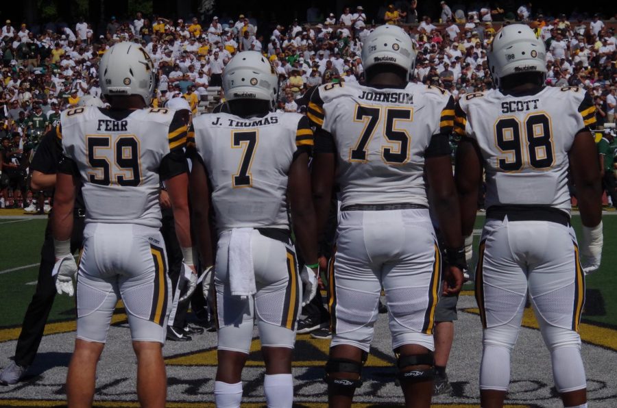 Permanent football captains Jordan Fehr, Josh Thomas, and Victor Johnson stand next to temporary captain EJ Scott before App State's 56-41 victory over Charlotte on Sept. 7. 