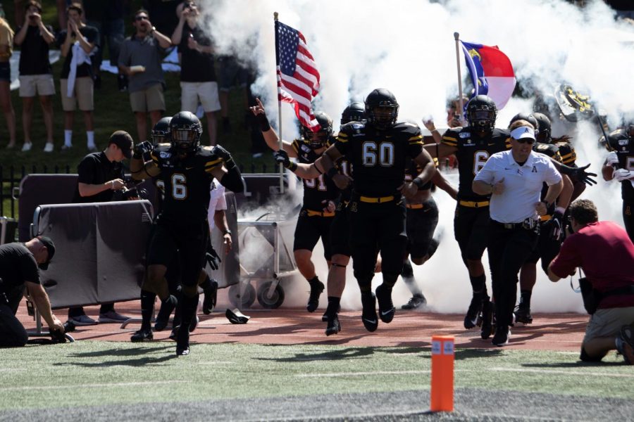 Senior captain & safety Desmond Franklin (left) takes the field alongside junior offensive lineman Noah Hannon (center) and head coach Eliah Drinkwitz (right) before App States 42-7 victory over East Tennessee State on Aug. 31. // Photo courtesy of App State Athletics