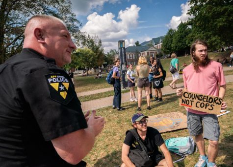 App State Police Chief Andy Stephenson talks to protestors about the cadet program and policing on campus during the Fewer cops, more doctors demonstration on Sanford Mall Wednesday afternoon. 