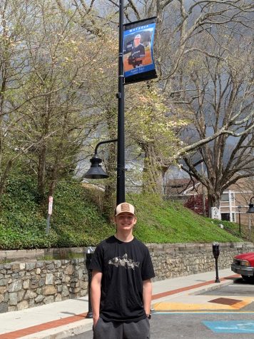 Watauga High School senior baseball player Austin Idol poses under his banner on King Street in downtown Boone.