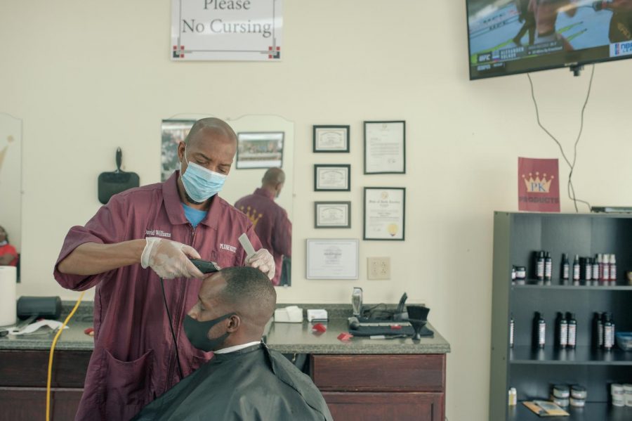 David Williams cuts a customers hair in Plush Kutz barbershop in Hickory, N.C. on June 19, 2020. Williams is a city of Hickory councilman and listens to many voices as they talk about "all the world's problems" in his barbershop.