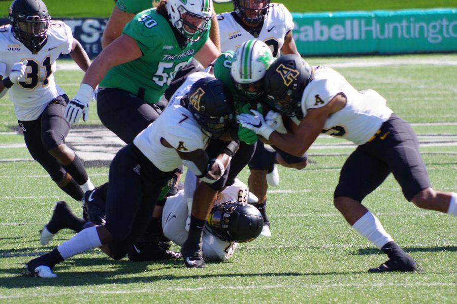Two Mountaineers combine for a tackle in the 17-7 loss at Marshall Sept. 19. 