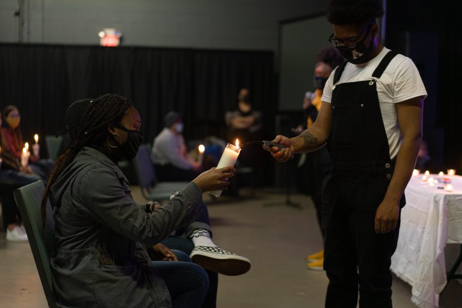 Jay Edwards (right) lights an attendees candle in honor of Breonna Taylor. 