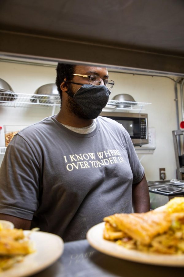 Ambrose working diligently in the kitchen, plating food and getting it out to customers.