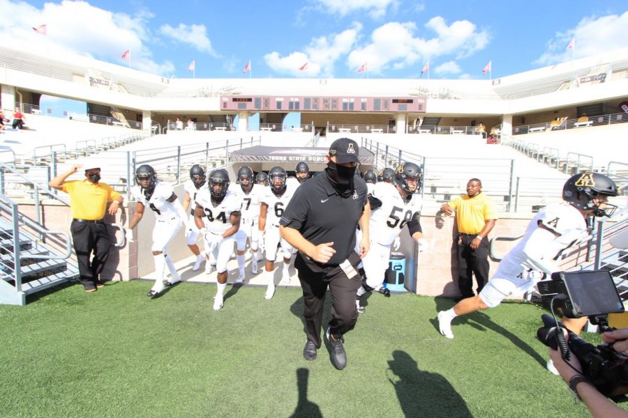 App State head coach Shawn Clark leads the Mountaineers onto the field ahead of the 38-17 victory over Texas State at Bobcat Stadium in San Marcos, Texas Nov. 7.