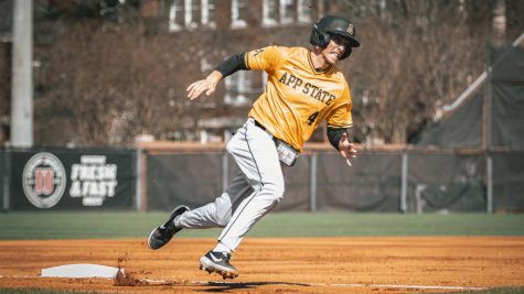 App State junior middle infielder Luke Drumheller hustles around third base during a game at UNC Greensboro last season. The Charlotte native broke out in his freshman season of 2019, leading the Mountaineers in batting average, hits, RBIs, doubles and OBP, en route to being named a freshman all-American by Collegiate Baseball News.