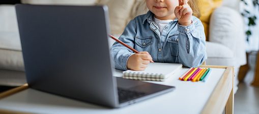 Little girl taking online courses in living room