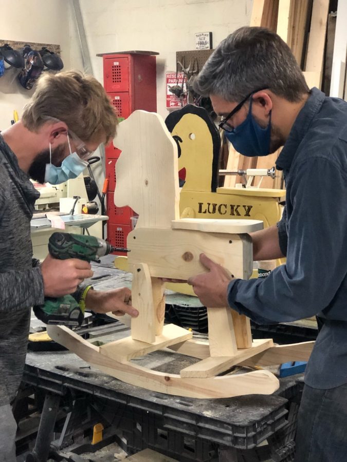 Danny Combs(right) helping a student build a rocking horse. Combs left his music career to create Teaching the Autism Community Trades, which teaches students trade skills like woodworking. 