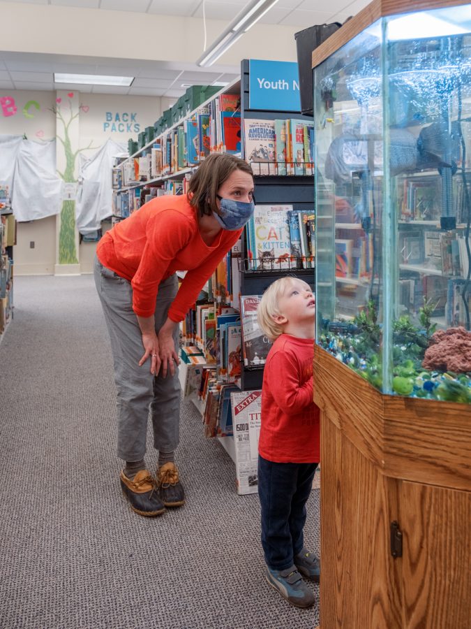 Among the most excited to see returning patrons is the resident pet fish, seen here inspecting a parent and child in the library. 

