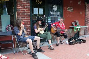 Jacob Moore (left) and Alex Woodbury (right), joined by a third musician, performing outside of the art market.