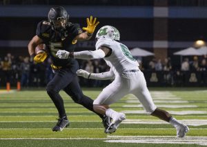 Super senior receiver Thomas Hennigan stiff arms a defender on one of his nine receptions on the night. Hennigan caught nine of his 10 targets, racking up 123 receiving yards against the Thundering Herd. 