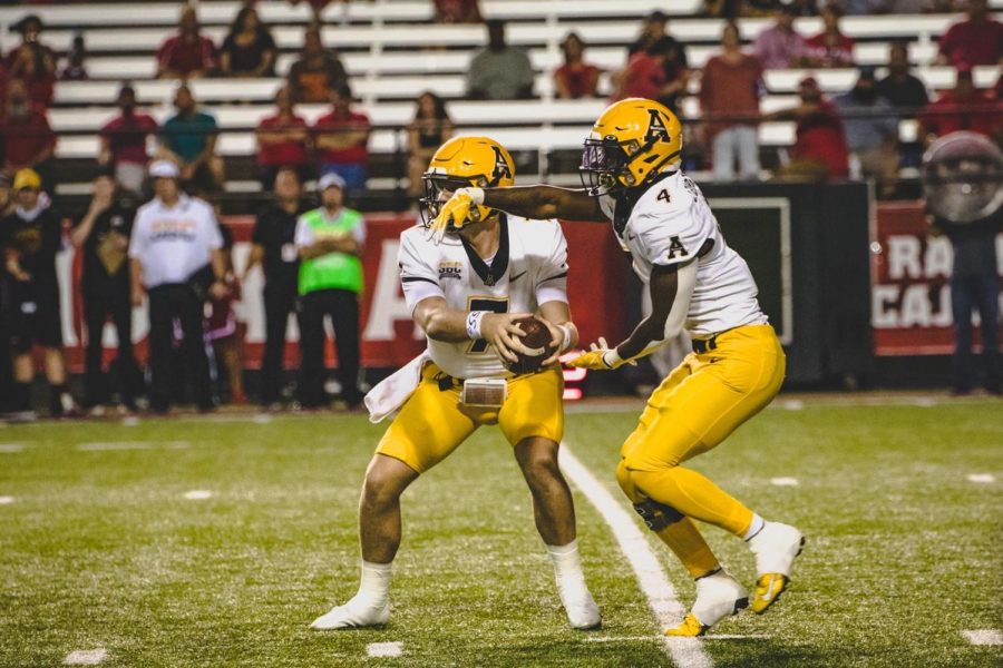 Graduate transfer Chase Brice hands the ball off to senior Daetrich Harrington. Harrington ran for 11 yards on two attempts in his first game back from injury in 2021. 