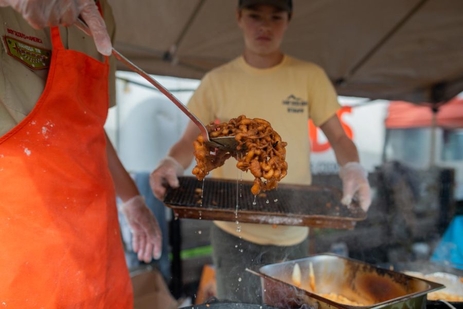 Sawyer Kennedy of the Boy Scout troop 109 dips out funnel cake for customers during the Valle Country Fair on Saturday in Valle Crucis. 
