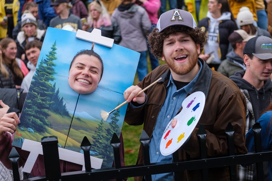 Two fans dress as Bob Ross and one of his paintings. With the homecoming game being one day before Halloween, many fans dressed up in costumes. 