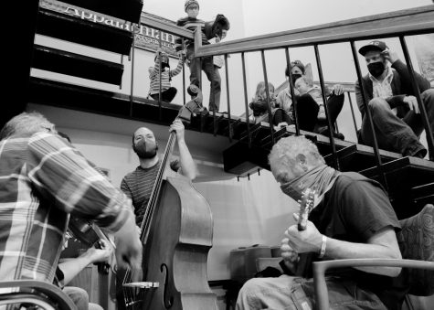 Passerbys listen to musicians playing bluegrass music in a stairwell alcove in Plemmons Student Union during the Fiddler’s Convention Feb. 5, 2022.