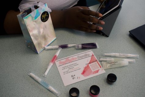 Zalaya Hinton offers on-campus pickups for her cosmetic products. Hinton bags items in a metallic baggie with a sticker thanking customers for shopping.