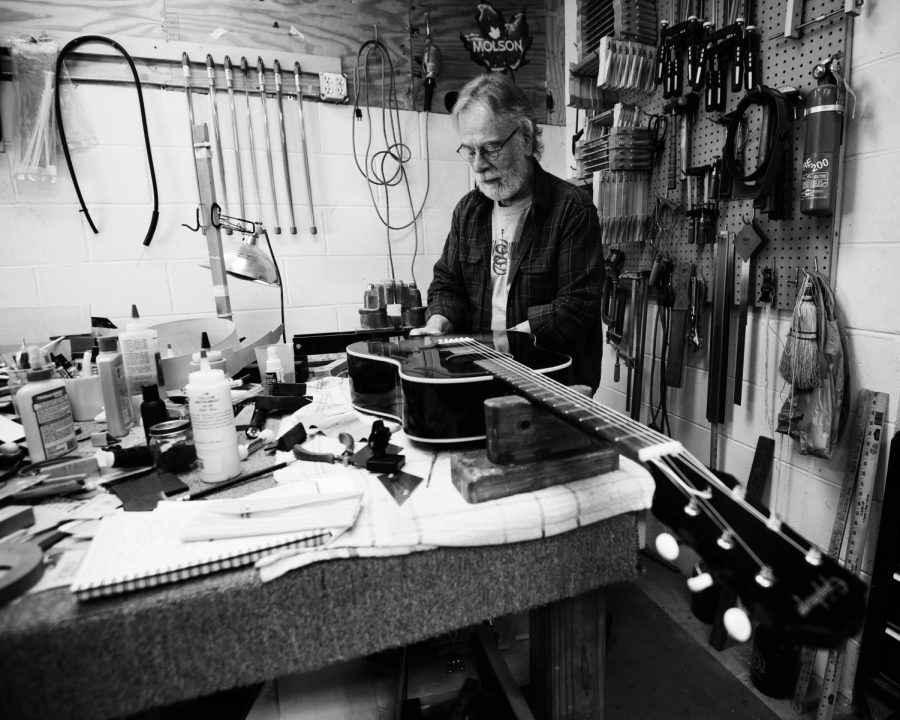 Mike McKee makes minor repairs to a guitar in his workshop, Feb. 21, 2022.