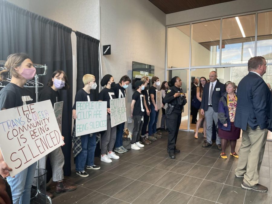 
ClimACT members hold signs and chant as attendees exit the meeting, March 25, 2022. 
