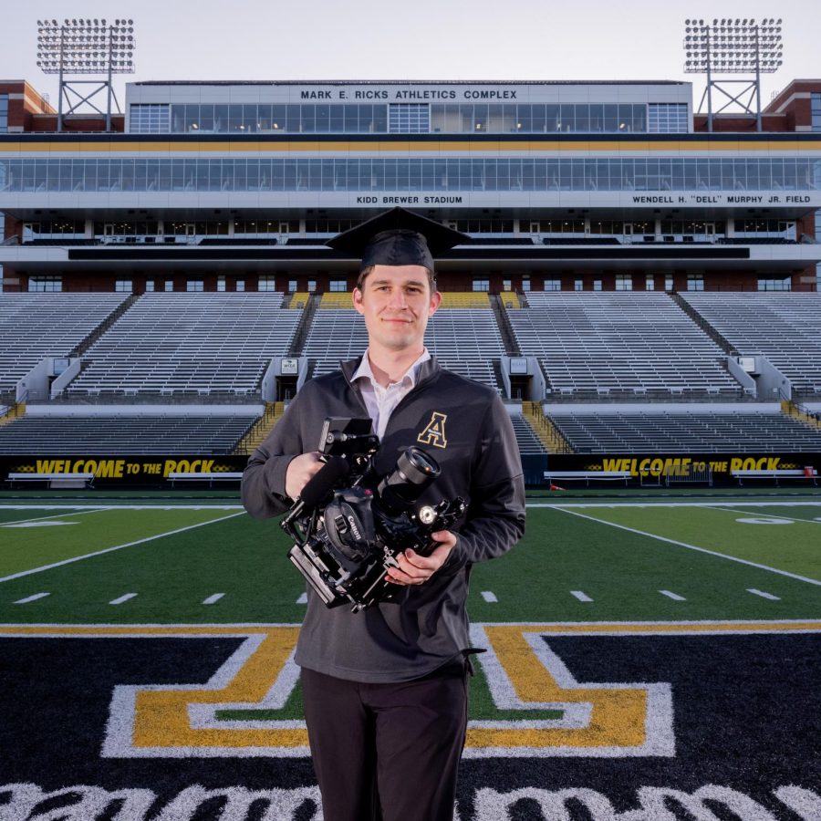 Senior+football+videographer+Max+Renfro+holds+his+camera+for+a+portrait+at+Kidd+Brewer+Stadium+March+27%2C+2022.+