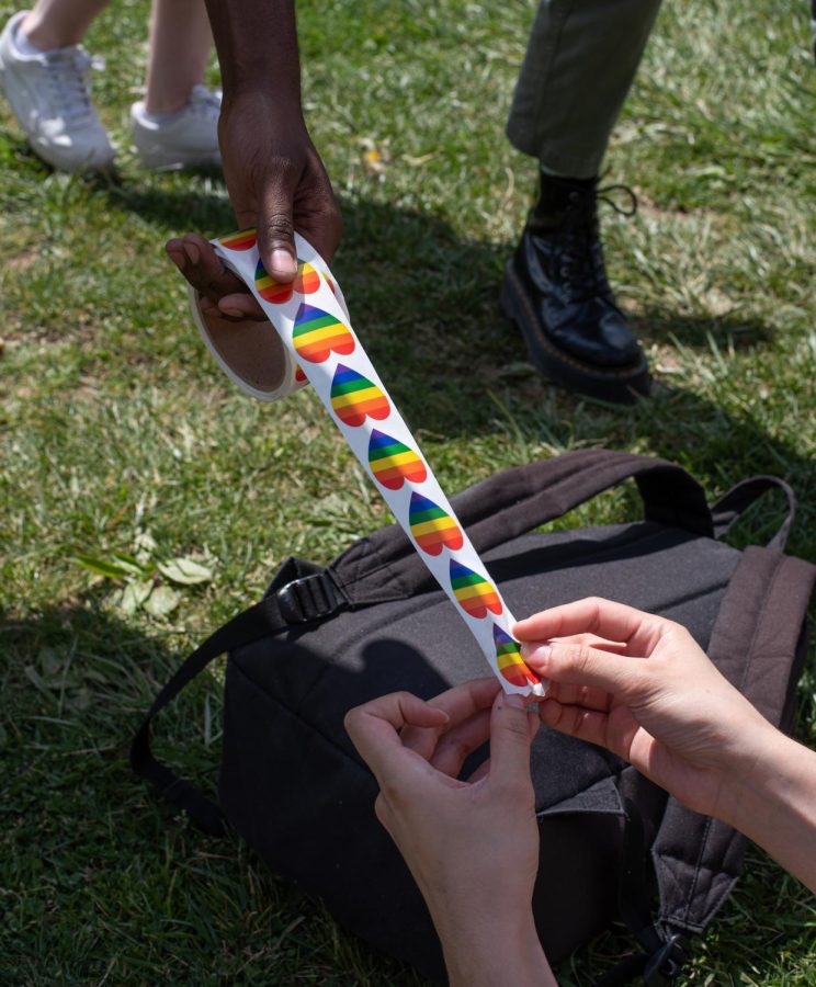 Justice Taylor gives pride stickers to students at the rally on Sanford Mall April 22, 2022.
