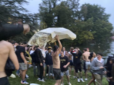 Fans break off a part of the duck pond sculpture and bring it to land before throwing it back into the pond after App State’s win over No. 6 Texas A&M.