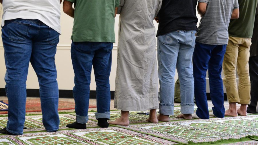 Attendees of the Jummah prayer stand barefoot as they participate in the prayer service.