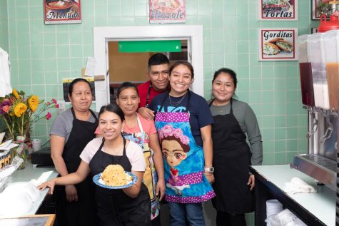 Miriam Hernandez and her team at Taqueria La Monarca posing for a group photo. Miriam holds gorditas in her hand, a popular Mexican dish.  