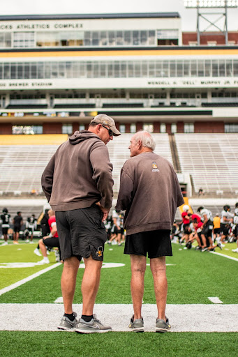 Head coach Shawn Clark shares words with Hall of Fame coach Jerry Moore at the team’s practice.
