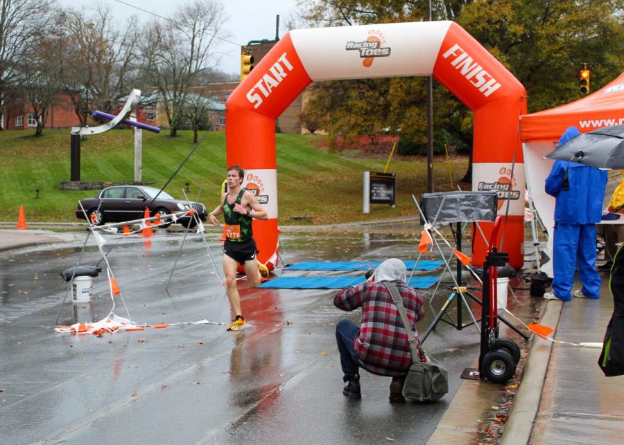  Rylan Haskett runs through the finish line, placing as the Male Overall winner for the 5K portion of the race (Nov. 5, 2022).
