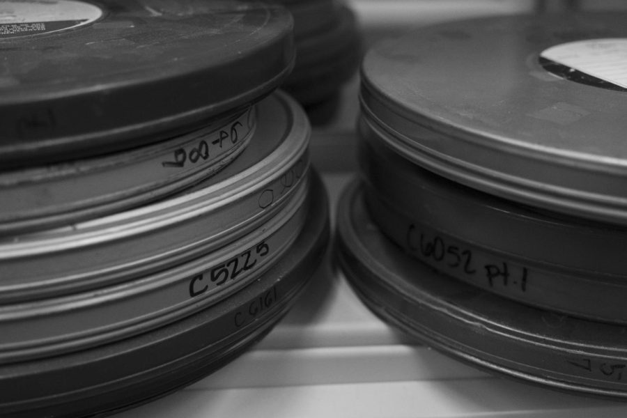 Old film rolls collect dust on a shelf on the lower level.