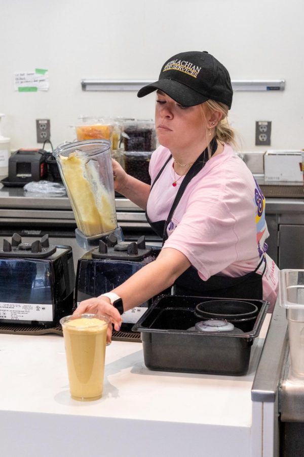 Madison Heye, an employee at Cascades, serving a Merry Mango smoothie for a customer. Cascades is located in Plemmons Student Union.