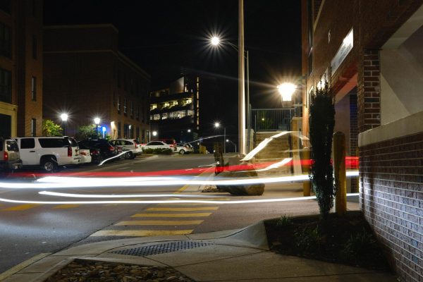 Cars rush into the Stadium Parking deck at night.