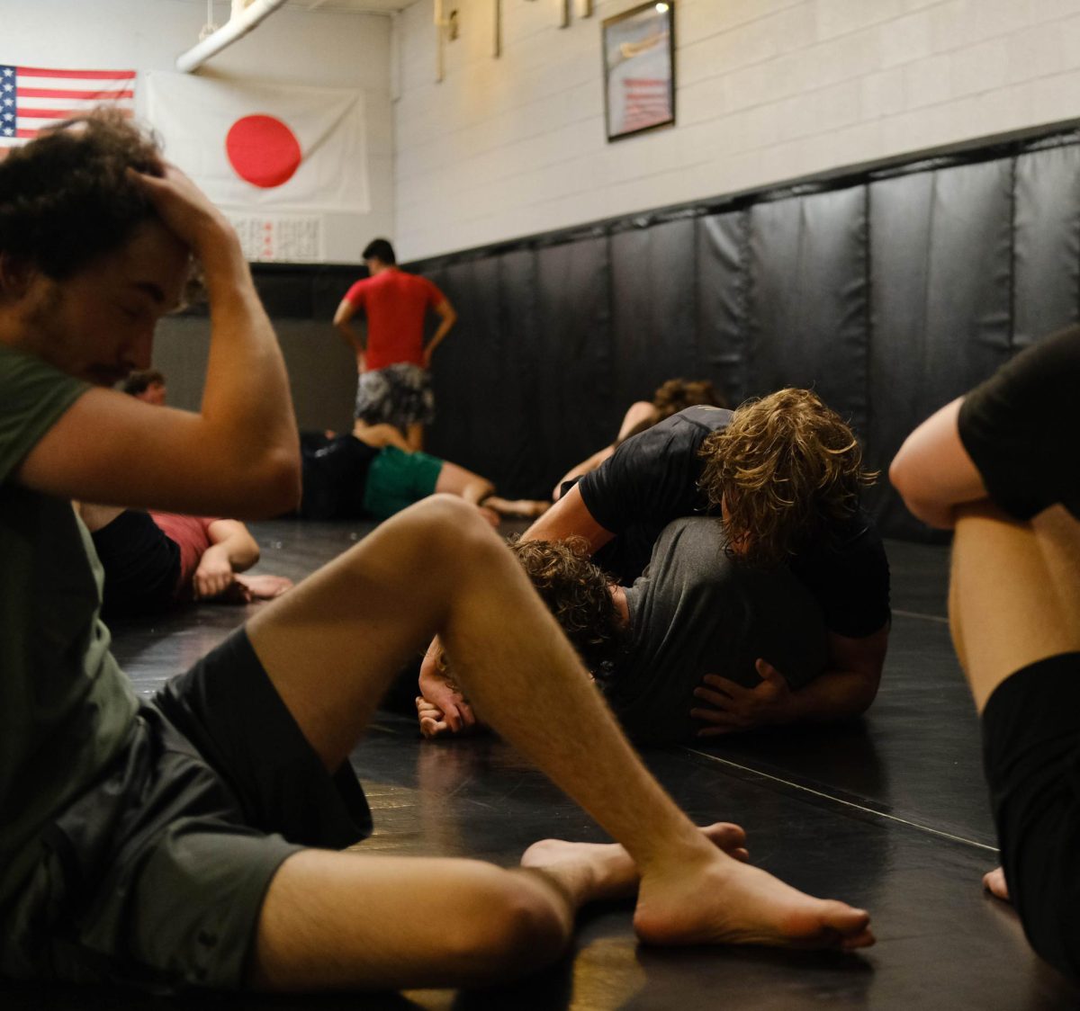 Two students grapple while others rest in between rounds at a jiu-jitsu club meeting Sept. 9, 2023.