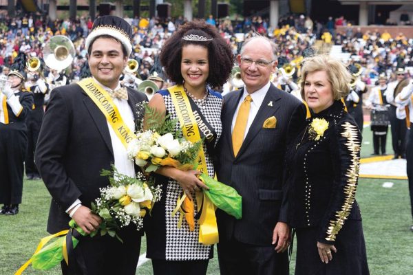 Chancellor Kenneth Peacock and his wife Rosanne Peacock stand with the 2012 Homecoming King, then senior secondary math education major Ish Gomez, and Queen, then senior theatre arts major Pami Cuevas, at the 2012 Homecoming game against Elon University. Photo by Paul Heckert | The Appalachian