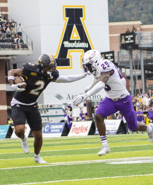 Redshirt junior wide receiver Kaedin Robinson stiff-arms a James Madison defender Sept. 24, 2022. Robinson caught five passes for 57 yards in the teams last matchup.