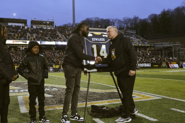 Former App State quarterback Armanti Edwards shakes hands with Director of Athletics Doug Gillin during Edwards jersey retirement ceremony Nov. 25, 2023.