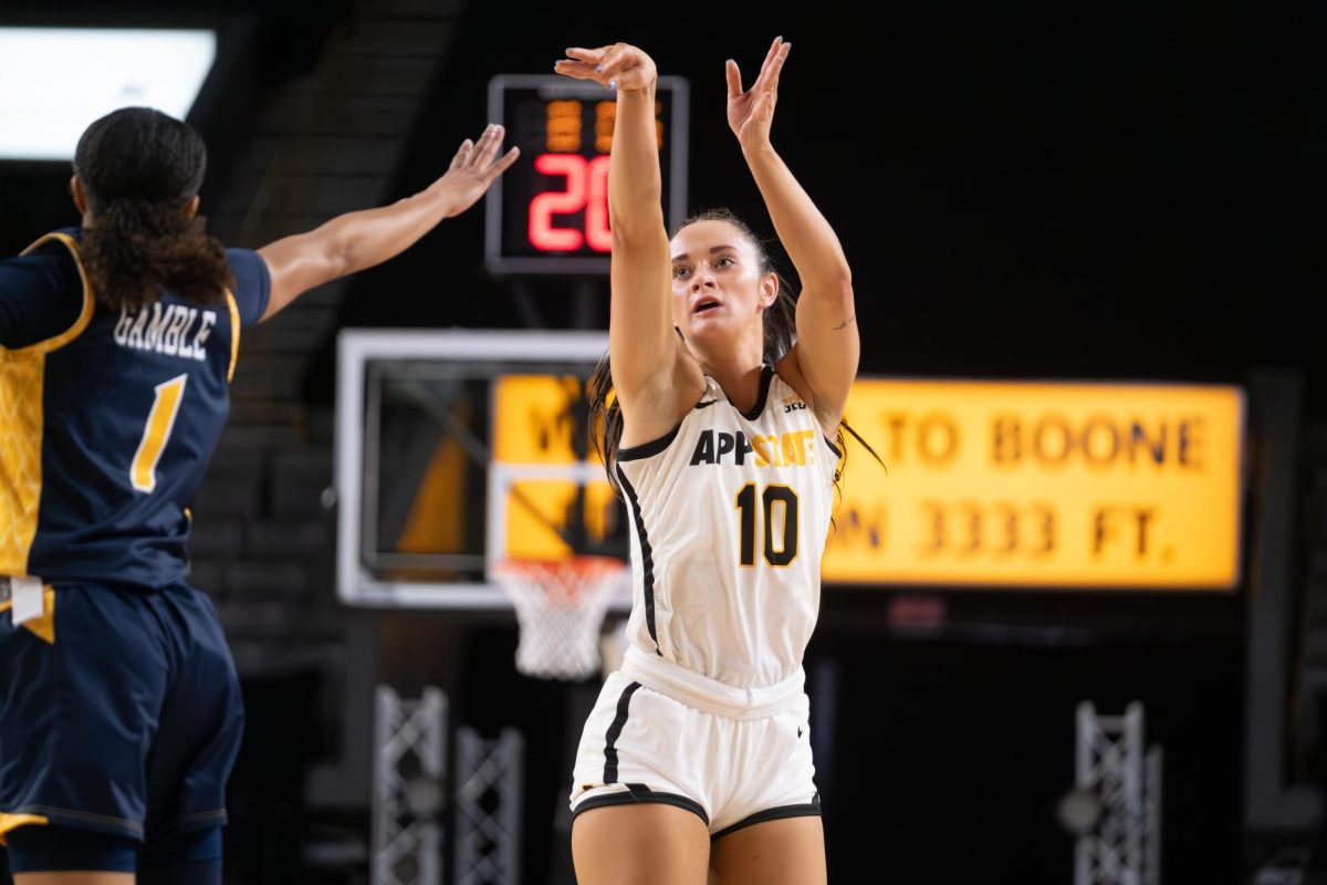 Emily Carver takes a jump shot against UNC-Greensboro’s junior guard, Jayde Gamble, on Dec. 13, 2023. Carver, a sophomore, averages 15.5 points per game.
