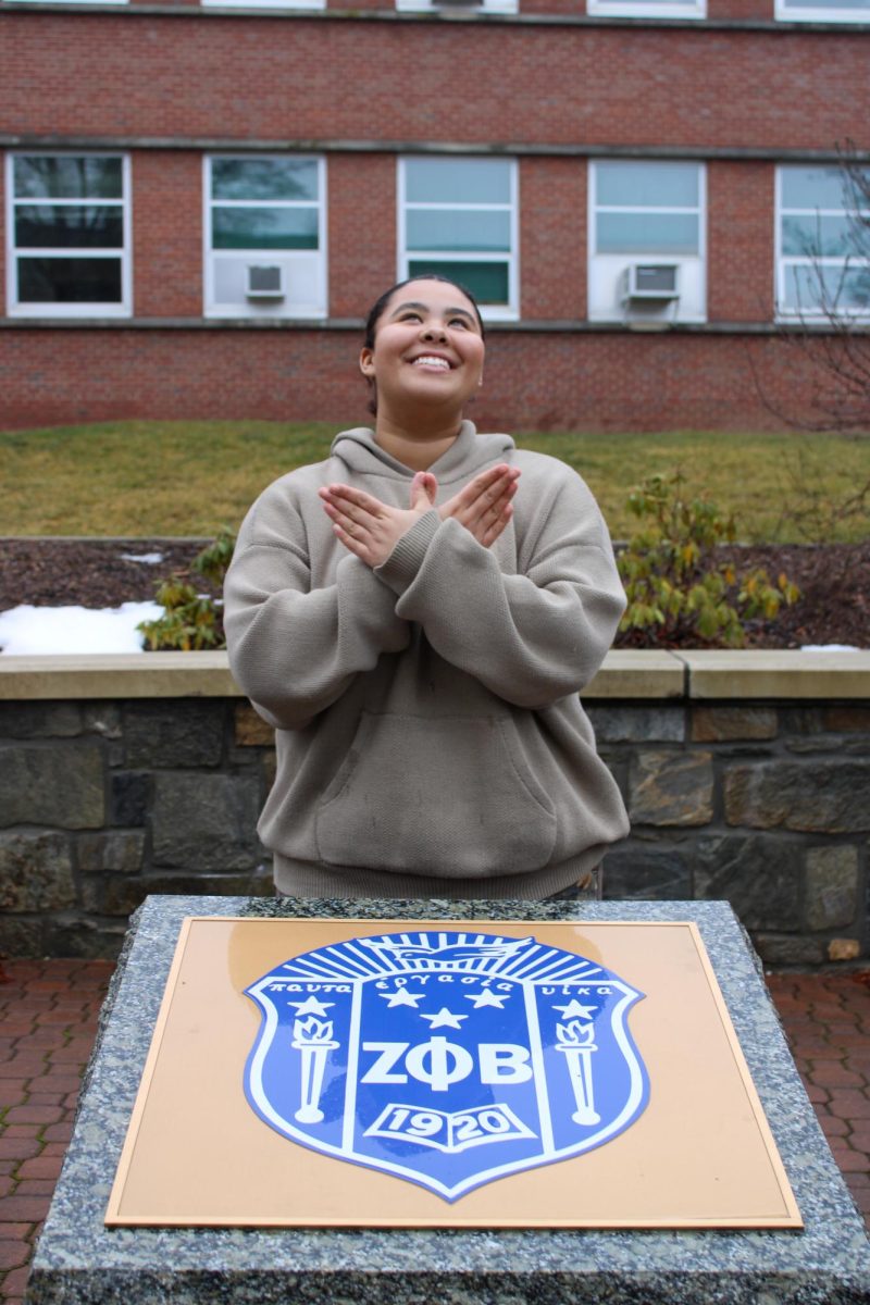 Zoe Horton is a junior here at App State and she is part of the Mu Omicron Chapter of  Zeta Phi Beta. She throws up her sign behind her sororitys plaque at the plots. Photo taken on Jan. 24, 2024. 
