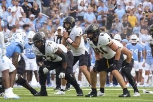 Quarterback Joey Aguilar prepares to take the snap against No. 17 North Carolina Sept. 9. Aguilar will return to the Mountaineers in 2024.
