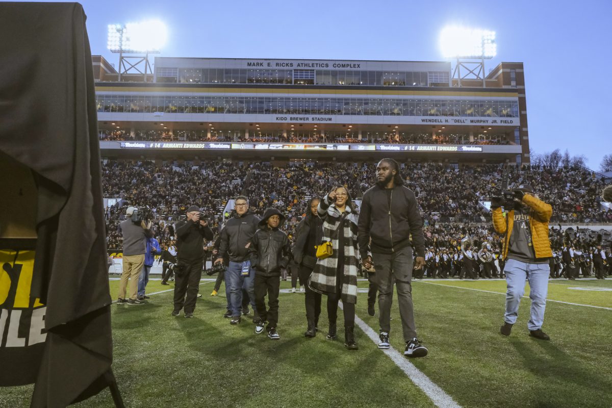 Former App State quarterback Armanti Edwards walks off the field with his family after getting his jersey retired at halftime of the Georgia Southern game Nov. 25.