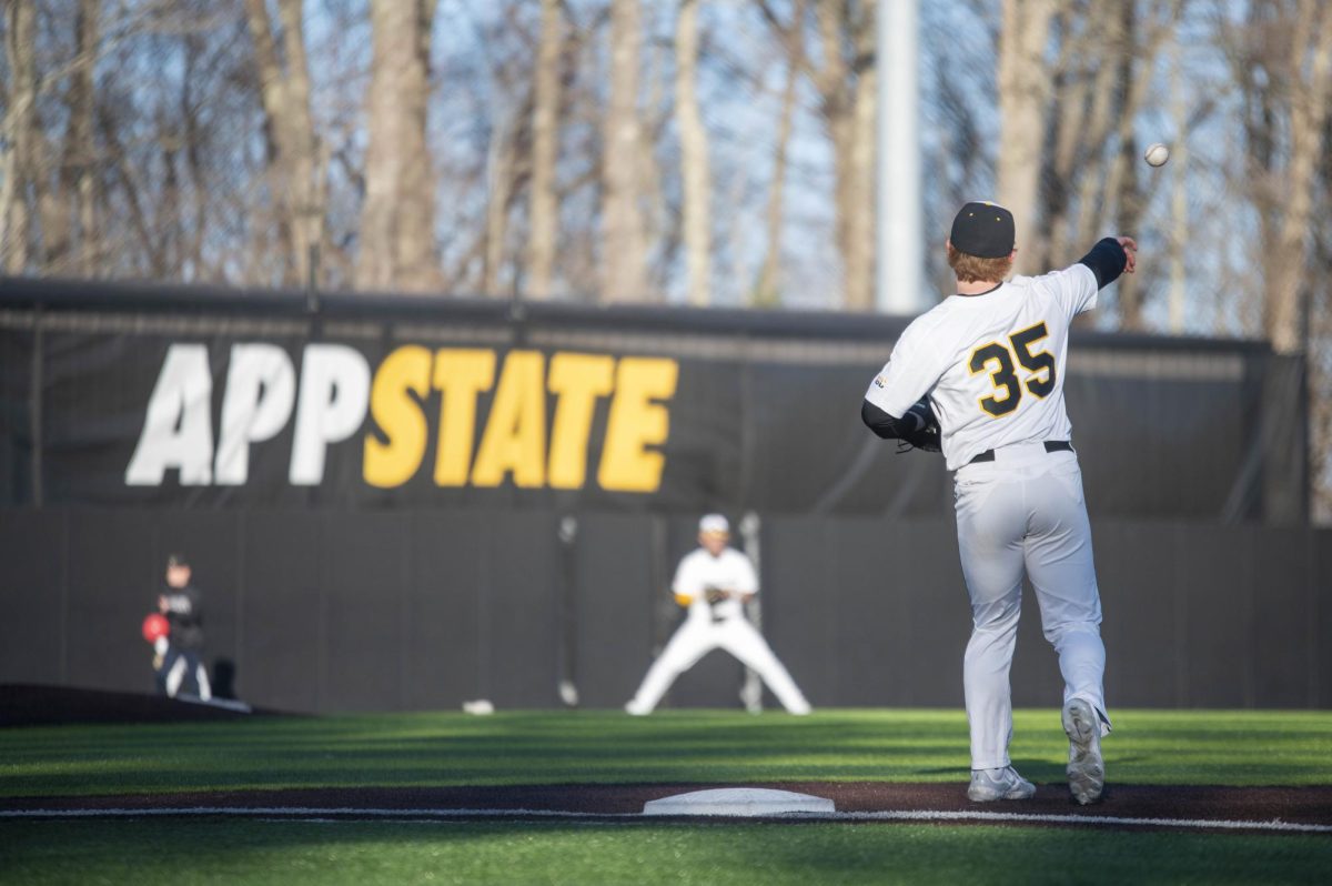 Graduate student first baseman Drew Holderbach throws the ball around the bases on March 28, as a part of the teams routine after getting an out.