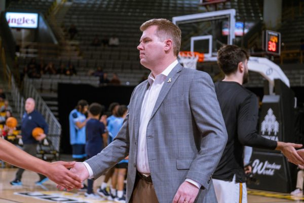 App State mens basketball head coach Dustin Kerns shakes hands with his players during pre-game warmups against Old Dominion Feb. 28. Kerns and his staff gained two commitments over the weekend.