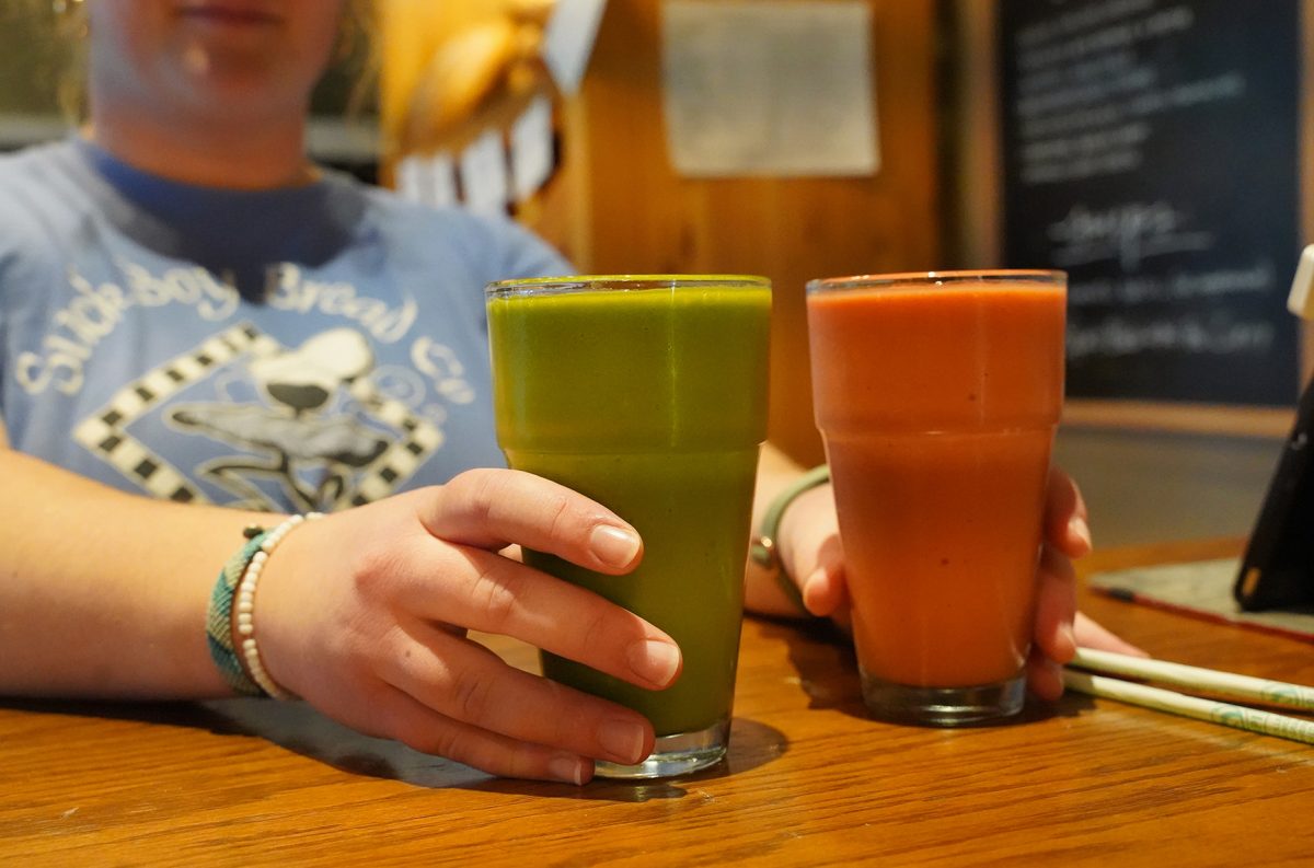 Stick Boy Kitchen’s Spring Green (left) and Mangoes & More (right) smoothies made on March 6 are just two of several delicious smoothies served on the menu. Both smoothies are made with an orange juice base and blended with fruits and veggies.
