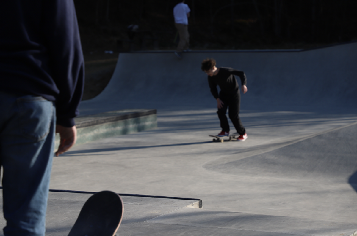 A+skater+looks+at+another+skateboarder+riding+in+the+Boone+Greenway+Skatepark%2C+March+2023.