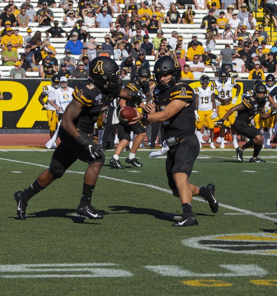 Junior running back Darrynton Evans prepares to take a handoff from junior quarterback Zac Thomas in App State's 42-7 win over East Tennessee State on Aug. 31, 2019.