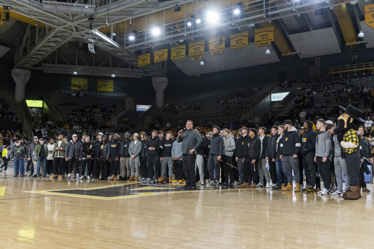 Football coach Shawn Clark with the 2023-24 team on the court at Holmes Convocation Center on Jan. 20. Clark led the team to victory against the Miami RedHawks in the 2023 Cure Bowl.