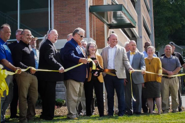 Interim Chancellor Heather Norris (center left) cuts the ribbon alongside John Morrison (center right) and several other collaborators celebrating the completion of the Holmes Drive Parking Deck on Aug. 22. Construction on the parking deck started in June of last year.