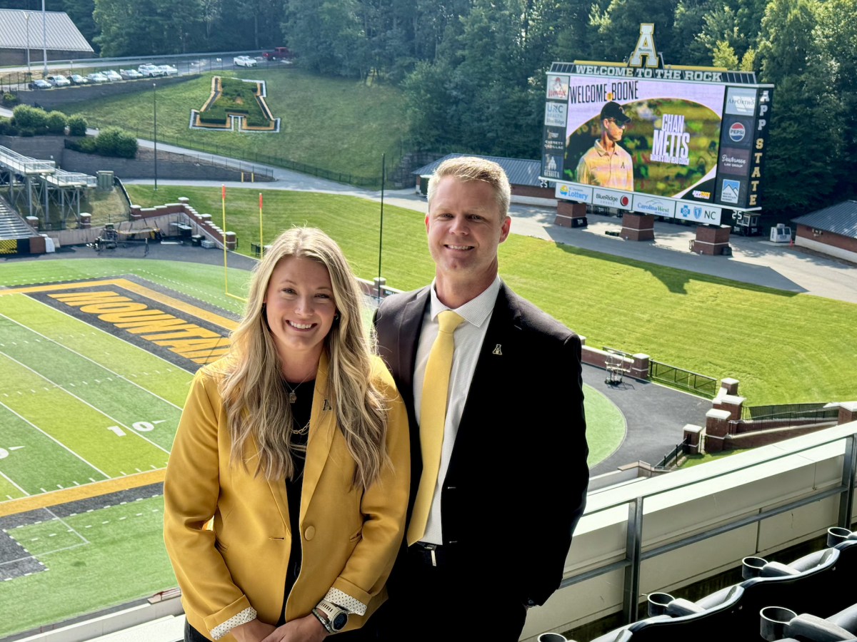 Chan Metts and his wife Whitney Metts pose for a photo at Kidd Brewer Stadium on Aug. 22. Chan Metts is the Big South Women’s Golf Coach of the Year and was announced as head coach for women’s golf. 