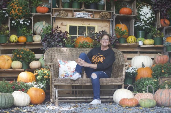 Cece Shore, owner of J&M produce stand, poses in front of a seating and photo area on Sept.15.