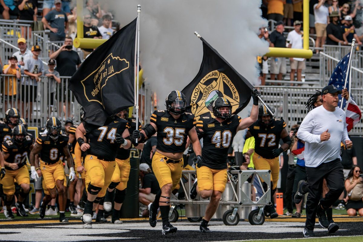 Inside linebackers Jack Scroggs and Cole Becker lead the Mountaineers on to the field to take on East Tennessee State on Aug. 31. Fans cheer as the team makes their first appearance for the 2024 season.